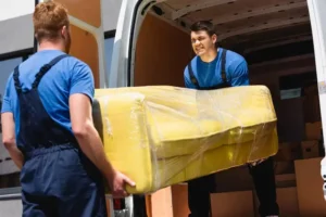 selective-focus-movers-unloading-sofa-stretch-wrap-truck-outdoors_824701-2855 (1)